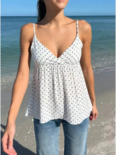 White polka dot v neck flowy cami with spaghetti straps and gathered waist in lightweight fabric for casual wear