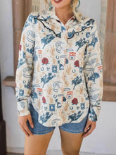 Cream-colored long sleeve printed button up shirt with blue and red cowboy motifs and black ruffled collar trim