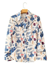 Cream-colored long sleeve button up shirt with rodeo-themed blue and red cowboy and horseshoe pattern