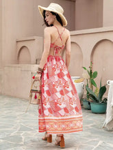 Woman in coral printed crop top and slit skirt set with straw hat