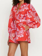 Lebhafter, bedruckter Langarm-Jumpsuit mit Gürtel in rot-pinkem Blumenmuster und Puffärmeln
