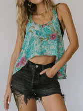 A teal and pink floral print sleeveless crop top with a relaxed fit featuring a printed scoop neck tank design