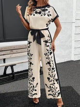 Cremefarbener Jumpsuit mit weitem Bein, schwarzer Blumenstickerei und Gürtel