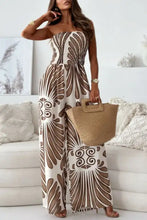 Woman in printed smocked tube wide leg jumpsuit, off-white with brown patterns