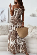 Woman in printed smocked tube wide leg jumpsuit with geometric pattern