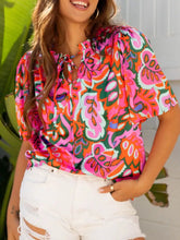 Vibrant pink orange and green paisley printed tie neck short sleeve blouse with flutter sleeves and light fabric