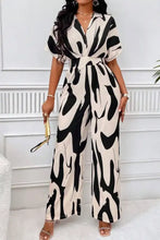 Zwart- en crèmekleurige jumpsuit met brede pijpen en zebraprint, V-hals en taille met ceintuur