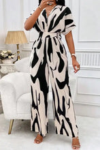 Stijlvolle zwarte en crèmekleurige jumpsuit met zebraprint, wijde pijpen, V-hals en korte mouwen
