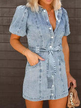 Light-wash mini denim dress with puff sleeves, button-front closure, and self-tie waistband in a casual style