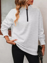 Light gray quarter zip dropped shoulder sweatshirt with black zipper detail made of slightly stretchy material machine wash cold