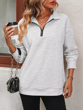 Quarter zip dropped shoulder sweatshirt in soft heather gray made of slightly stretchy material with black zipper and ribbed cuffs designed for machine wash cold