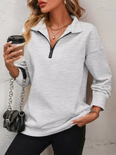 Quarter zip dropped shoulder sweatshirt in heather gray with black zipper ribbed cuffs made of slightly stretchy material machine wash cold