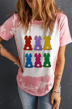 Woman modeling pink and white bleach-dyed rabbit round neck short sleeve t-shirt with colorful bunny graphic