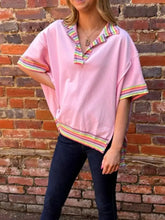 Pink ribbed knit short-sleeved top with rainbow trim collar cuffs hem and side slit ribbed knit polo design