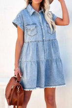 Light blue raw hem denim mini dress with short sleeves button front and two chest pockets in a denim dress style