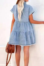 Light blue raw hem denim mini dress with short sleeves and tiered skirt in a button down style