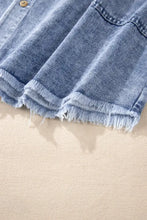 A light-wash raw hem long sleeve denim dress with a single wooden button and frayed hem detail