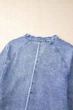 A light-wash long sleeve denim dress with raw hem and frayed crew neckline raglan sleeves