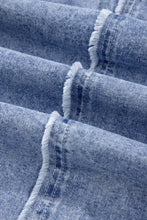 Light-wash long sleeve denim dress with raw hem frayed edges and textured faded blue finish