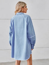 Light blue denim dress with raw hem button closure and frayed edges in a relaxed oversized fit