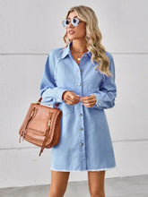 Light blue denim dress with raw hem button front design and frayed hem detail in light denim fabric