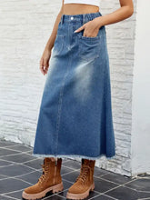 A mid-blue denim skirt with raw hem, waist stretch, buttoned front, and two practical front pockets
