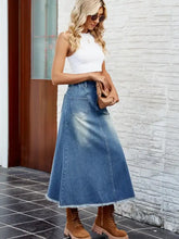 A mid-blue raw hem denim skirt with front pocket and waist stretch detail for casual wear