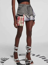 Raw hem denim mini skirt with distressed gray upper and vibrant red white beige plaid patch details with frayed edges