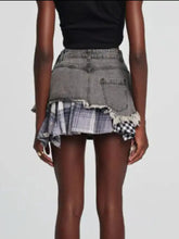 Distressed gray raw hem denim mini skirt featuring layered plaid patch details and a ruffle hem