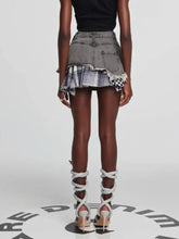 Distressed gray raw hem denim mini skirt with layered plaid patch details and frayed edges for casual wear