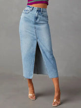 Light-wash raw hem denim midi skirt with front slit and frayed hem for casual and stylish wear