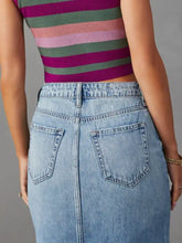 Back view of a light-wash raw hem denim midi skirt with classic pockets and visible stitching detailing