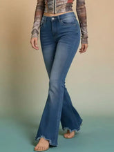 Blue denim raw hem high-waisted flare jeans with subtle fading and frayed hem detailing