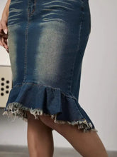 Dark blue raw hem mermaid denim skirt with a flared frayed hem showcasing raw hem detail