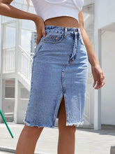Light-wash denim skirt with raw hem slit and frayed hem detail in a midi length style