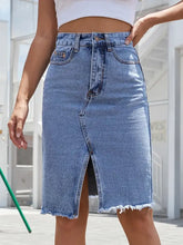 Mid-thigh length denim skirt with raw hem slit and frayed edges in classic blue raw hem denim skirt style