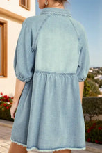 Light blue denim dress with collar puffed sleeves and raw hem snap detailing in raw hem snap down denim dress style