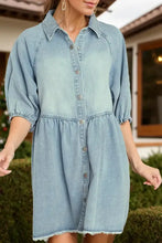 Light blue denim dress with raw hem snap detailing, button-front, and elasticated cuffs in half sleeve design