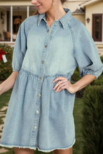 Light blue denim dress with raw hem snap button-down front, puffed sleeves, and flared skirt for casual wear