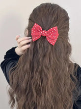 Red polka dot bow hair clip on long wavy brown hair