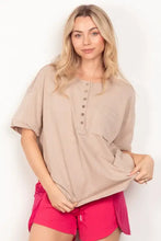 Woman in relaxed fit beige henley shirt with patch pocket and twisted sleeve band