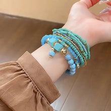 Wrist with turquoise and gold resin rice bead bracelet, various shapes