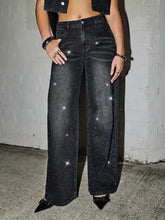 Black rhinestone embellished wide leg jeans featuring sparkling star-like embellishments on a wide leg jeans design