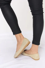 Sparkling gold rhinestone point toe flat slip-ons with black leggings