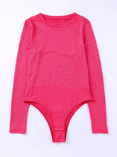 A vibrant fuchsia rhinestone round neck long sleeve sleeve bodysuit with a sparkling glittery pattern on torso and sleeves