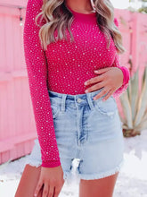 A vibrant fuchsia round neck long sleeve bodysuit with small white polka dots and rhinestone detailing