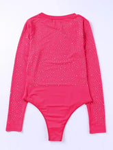 A vibrant pink rhinestone round neck long sleeve sleeve bodysuit with sparkling glittering pattern on torso and sleeves
