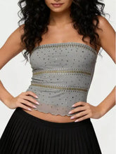 Gray rhinestone tube top with sheer dotted fabric and gold-toned embellishments along horizontal bands