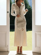 Cream-colored ribbed knit midi sweater dress with black trim and button front