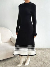 Black ribbed knit sweater dress with high neck, long sleeves, striped pleated hem